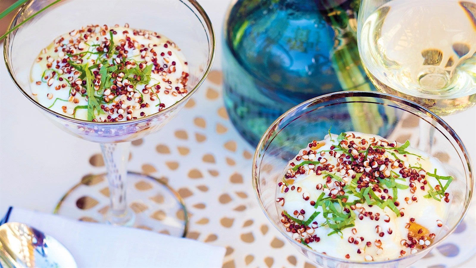  Martini glasses holding a dessert of yogurt and grilled peaches topped with puffed quinoa